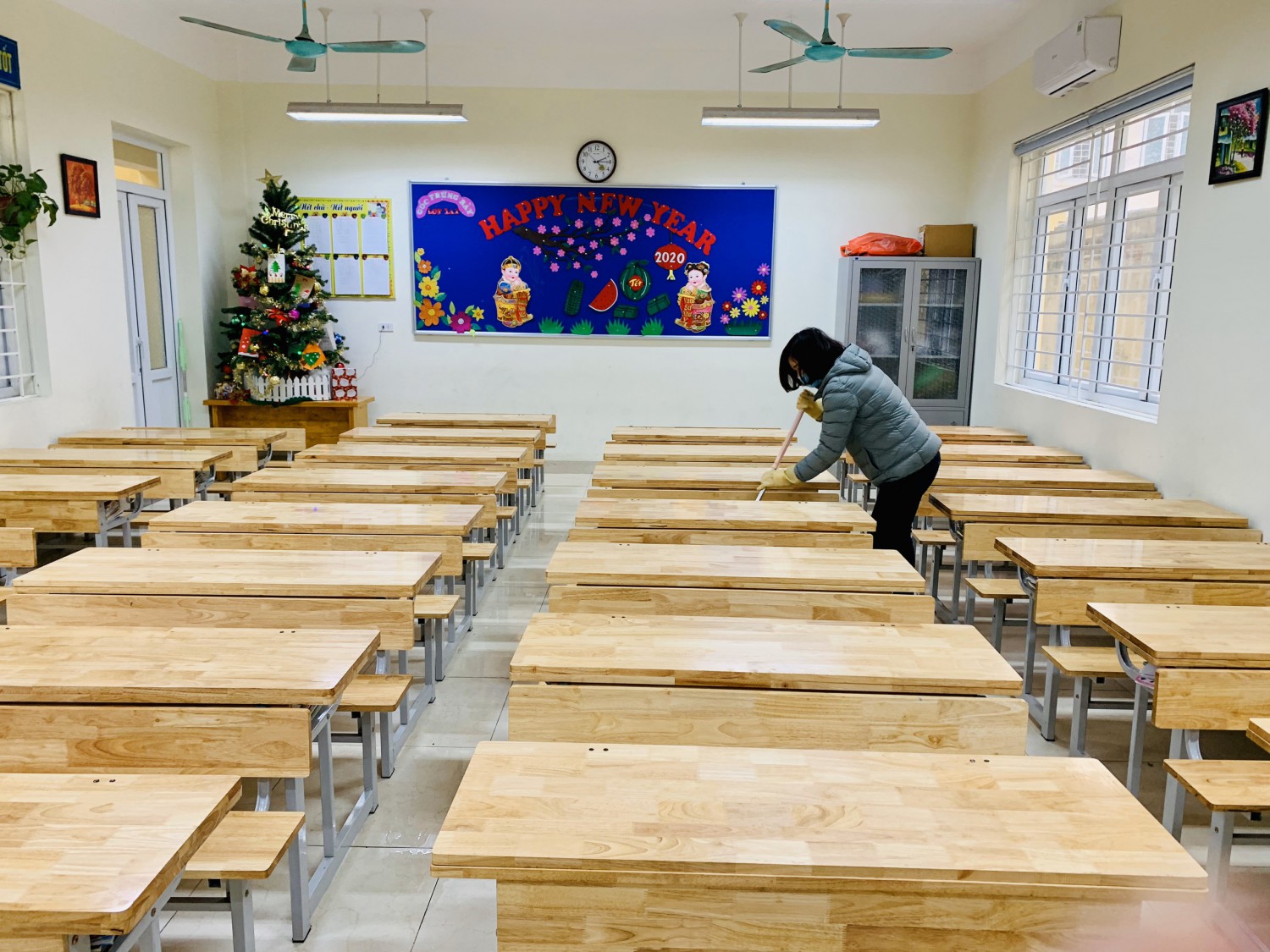 Giáo viên chủ nhiệm vệ sinh trong lớp học.